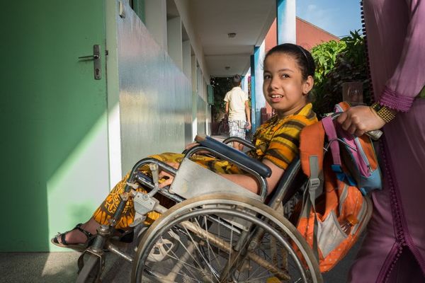 Ikram aus Marokko mit dem Rollstuhl in ihrer neuen inklusiven Schule. © Amminadab Jean/HI